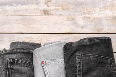 Ahşap arka planda farklı bir kot pantolon.