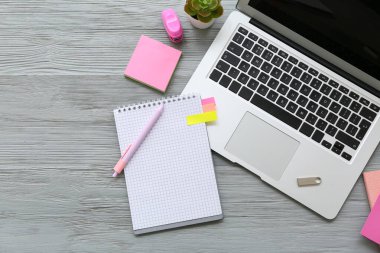 USB flaş bellekli dizüstü bilgisayar ve gri ahşap arka planda farklı bir kırtasiye.