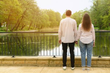 Güzel, sevgi dolu mutlu çift parkta el ele tutuşuyor.