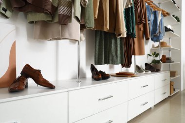 Butikte modern ayakkabılarla şık kıyafetler.