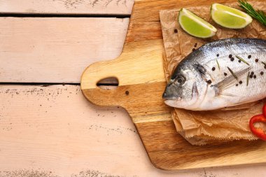 Açık ahşap arka planda limonlu çiğ dorado balığı