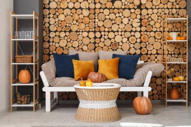 Kanepesi, sehpası ve balkabağı olan rahat bir oturma odasının sonbaharı.