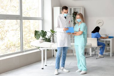 Kırmızı kurdeleli profesyonel doktorlar klinikte bir şey tartışıyorlar. Dünya AIDS Günü konsepti