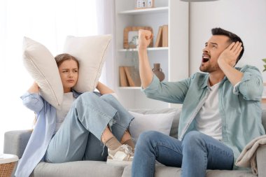 Young couple suffering from loud neighbours at home clipart