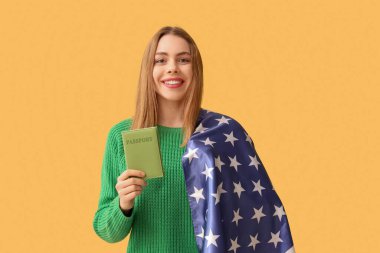 Sarı arka planda Amerikan bayrağı ve pasaportu olan güzel, genç bir kadın.