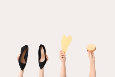 Beyaz arka planda şık ayakkabıları, tabanları ve fırçası olan kadın elleri. Ayakkabı tamiri kavramı