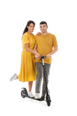Beyaz arka planda modern elektrikli scooter kullanan mutlu genç çift.