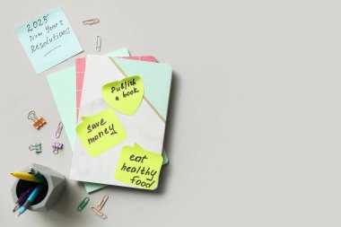 Planlar için yapışkan notlar, not defterleri ve gri arka planda kırtasiye malzemeleri. Yeni yıl hedefleri kavramı