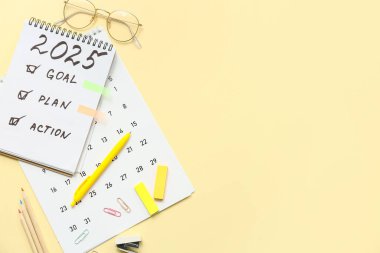 Sarı arka planda yapılacaklar listesi, takvimi ve kırtasiyesi olan defter. Yeni yıl hedefleri kavramı
