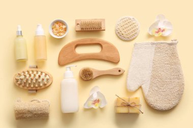 Ahşap guasha vücut masajı aracı ve bej arka planda banyo malzemeleri ile kompozisyon