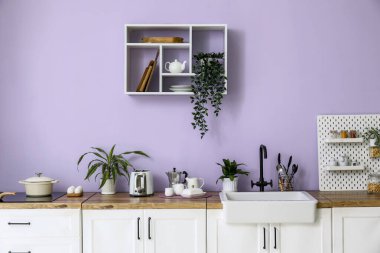 Beyaz tezgahlı, lavabolu ve tost makineli modern mutfak.