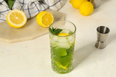 Limonlu bir bardak limonata ve beyaz arka planda nane şekeri.