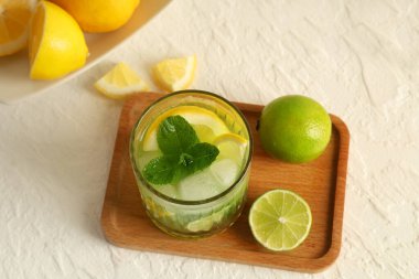 Lezzetli limonata, limon ve limon dolu ahşap tepsi beyaz arka planda