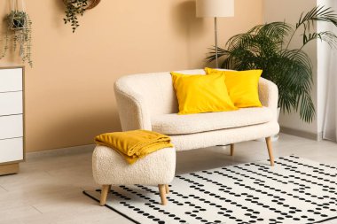 Beyaz kanepesi, puf ve halısı olan güzel bir oturma odası.