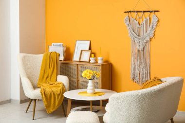 Beyaz koltuklu, yastıklı ve kahve masalı güzel bir oturma odası.