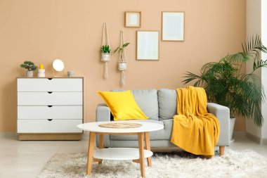 Rahat kanepesi, sehpası ve sarı ekoseli güzel bir oturma odası.