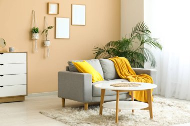 Rahat kanepesi, sehpası ve sarı ekoseli güzel bir oturma odası.