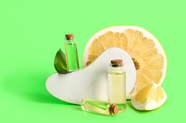 Yeşil arka planda kozmetik yağ şişeleri ve taze püre ile güzel kompozisyon, yakın plan.