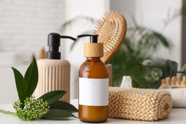 Banyodaki masada kozmetik ürünler ve banyo malzemelerinin bulunduğu güzel bir kompozisyon.