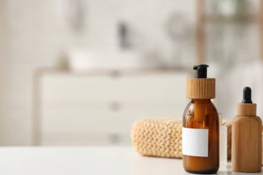 Kozmetik ürünleri ve banyo süngeri banyodaki masada, yakın plan.