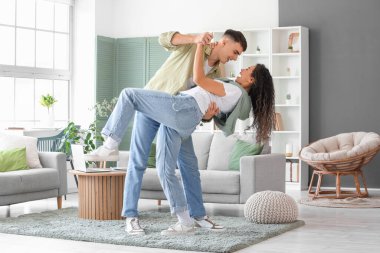 Happy young beautiful couple dancing at home