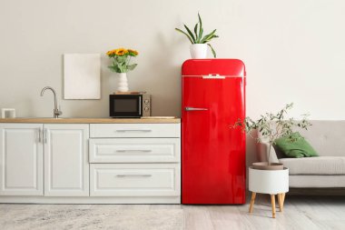 Kırmızı buzdolabı ve beyaz tezgahlı şık bir mutfak.