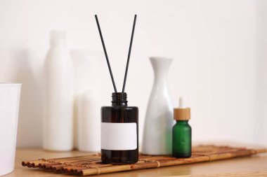 Aroma yayıcı, vazo ve kozmetik ürünleri banyoda, yakın plan.