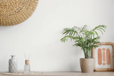 Aroma yayıcı, vazo, çerçeve ve saksı oturma odasındaki çekmecelerin üzerinde.