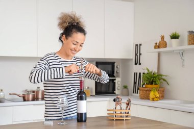 Şarabı evde açan orta yaşlı, güzel bir kadın.