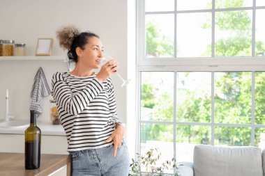 Evinde şişe ve bir bardak kırmızı şarapla orta yaşlı güzel bir kadın.