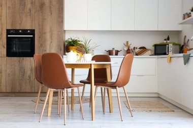 Mutfağın içinde yemek masası ve tezgahları var.