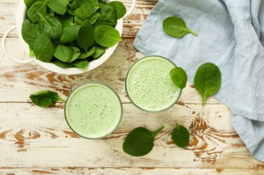 Beyaz ahşap arka planda taze ıspanaklı smoothie.