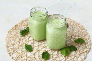 Mason kavanozları beyaz arka planda taze ıspanaklı smoothie.