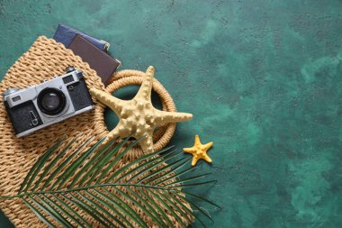 Yeşil grunge arka planda deniz yıldızları, çanta ve fotoğraf makinesi ile güzel kompozisyon