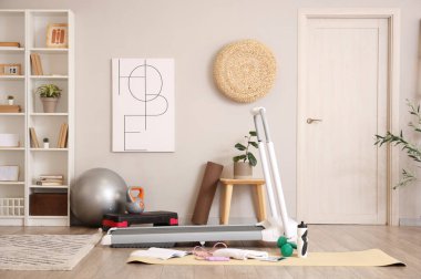 Koşu bandı ve spor ekipmanlarıyla ışık odasının içinde.