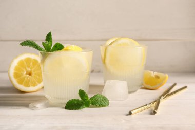 Nane şekerli taze limonata ve beyaz ahşap arka planda buz küpleri.