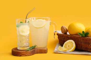Bir bardak taze limonata ve sarı arka planda nane şekeri.