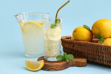Mavi arka planda naneli bir bardak taze limonata.