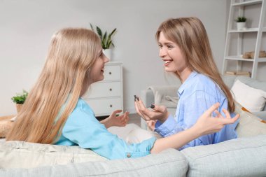 Evdeki kanepede oturan güzel, genç ve mutlu kardeşler.