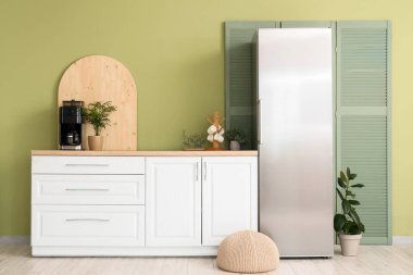 Beyaz tezgahı ve buzdolabı olan modern rahat mutfağın içi.