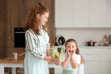 Annem mutfakta sürpriz küçük kızıma bir bardak smoothie veriyor.