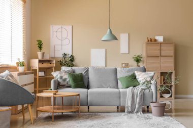 Konforlu kanepe, koltuk, sehpa ve ev bitkisi oturma odasında.