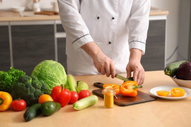 Taze sebzeli erkek şef mutfakta yemek pişirme videosu kaydediyor.