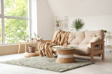 Oturma odasının içinde ekoseli ve kahve masalı yumuşak bir kanepe.