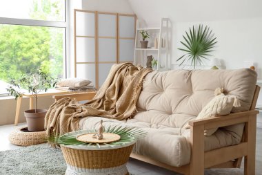 Oturma odasının içinde ekose ve kahve masası olan rahat bir kanepe.