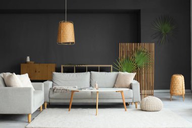 Oturma odasının iç tarafında rahat koltuklar, puf ve sehpa.