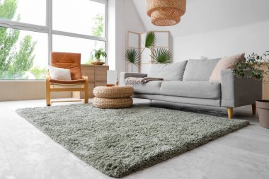 Konforlu kanepe, koltuk ve salonda dekorlu hasır puf.