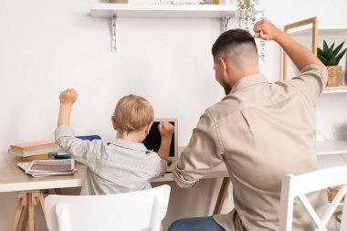 Baba, küçük oğlunun evde ders almasına yardım ediyor.