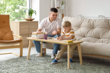 Babası ve küçük oğlu evde ödev yapıyor.