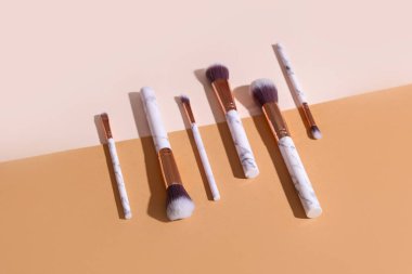 Renkli arkaplanda farklı stil makyaj fırçaları